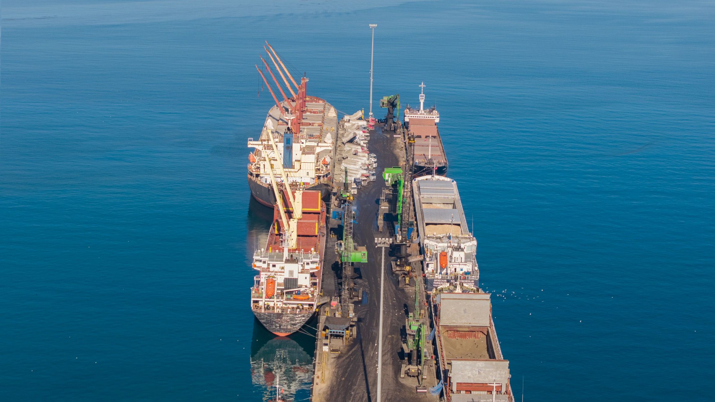 Aerial view of cargo ships docked at a busy industrial port