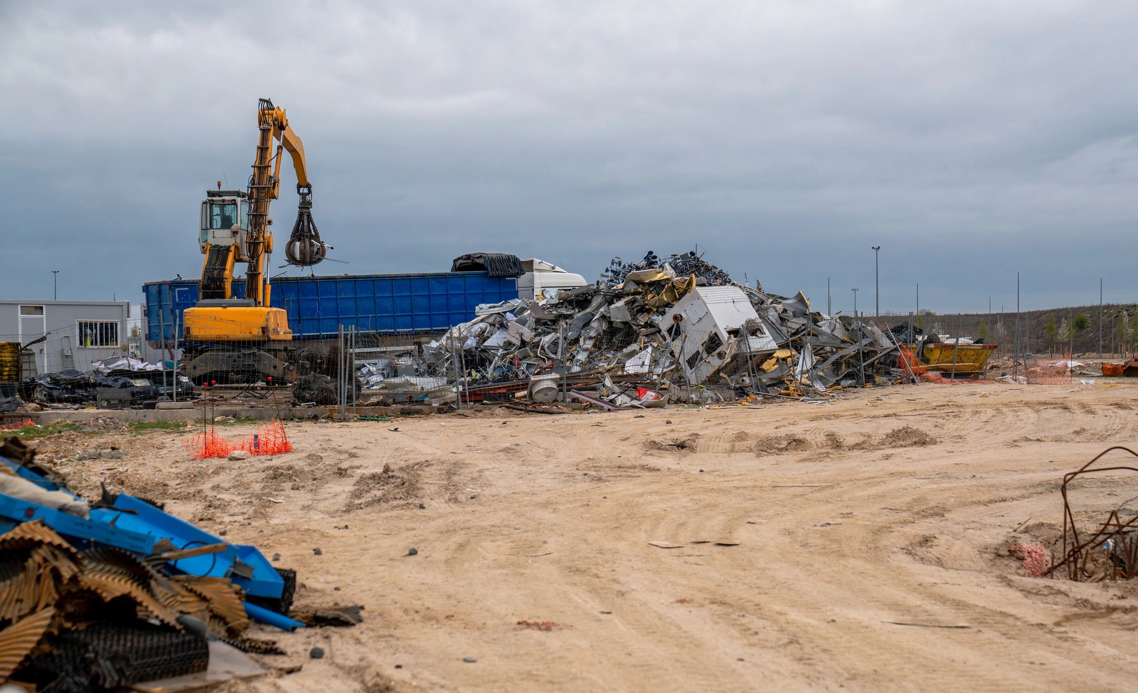 Industrial crane moving scrap metal at a recycling yard